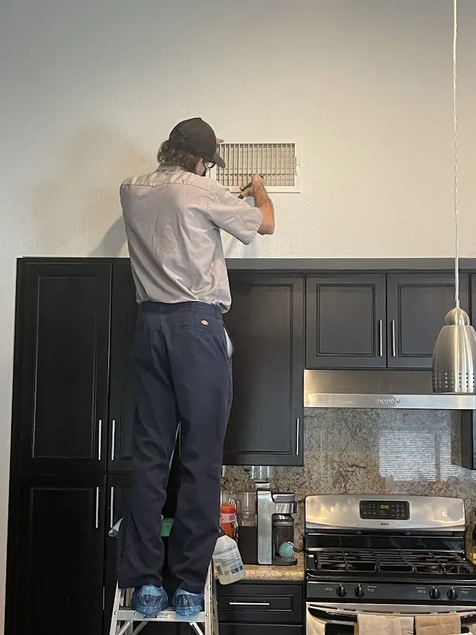 Technician inspecting an air vent during HVAC service in Plant City